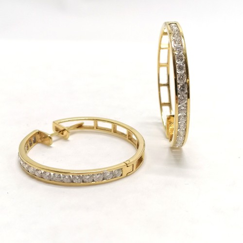 117 - Pair of unmarked yellow gold (touch tests as 18ct or higher) hoop earrings channel set with 18 diamo... 