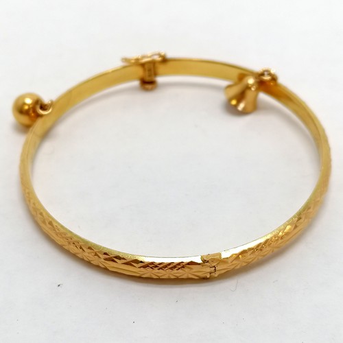 120 - Chinese gold marked high carat bangle decorated with 2 bells, screw down safety catch approx. 6cm di... 