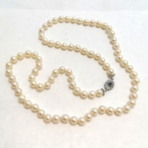 216 - 62cm strand of pearls with a 750 white gold clasp set with a blue stone - missing a claw - SOLD ON B... 