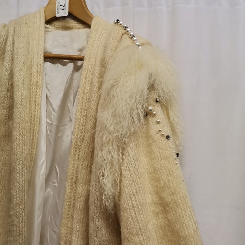 77 - 1980s knitted cream coat with pearl trimmed shoulders and sleeves and sheepskin trim, diamantes acro... 