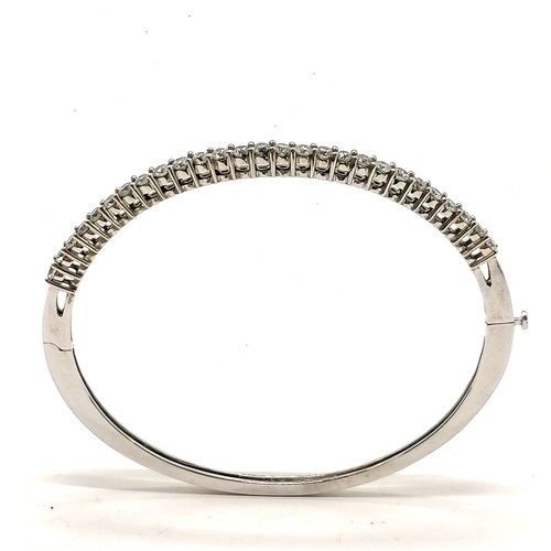 300 - 14ct marked white gold bangle set with 27 diamonds (approx 2.4mm diameter) - 6.5cm across x 5.5cm de... 