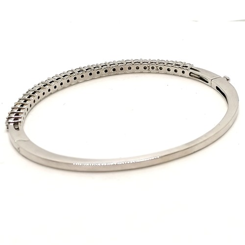 300 - 14ct marked white gold bangle set with 27 diamonds (approx 2.4mm diameter) - 6.5cm across x 5.5cm de... 