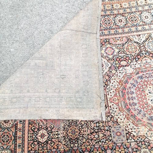 662 - Large antique pink, blue and black wool rug 345 cm wide. Has wear and a small hole to 1 corner