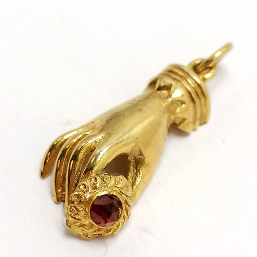 303 - 9ct marked gold hand holding flower (set with red stone) pendant - 2cm drop & 2.5g total weight