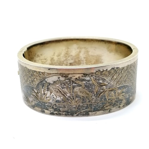 197 - Antique unmarked silver bangle with engraved decoration - 29g & 6cm across & has traces of original ... 