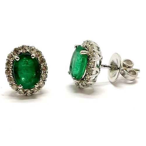 206 - 18ct marked white gold emerald (approx 7.8mm x 6mm) & diamond cluster earrings with screw back posts... 