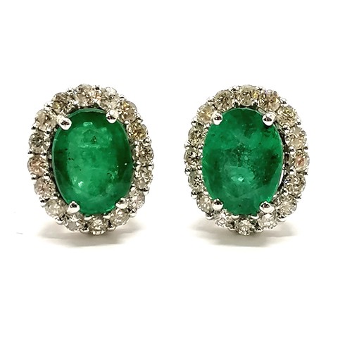 206 - 18ct marked white gold emerald (approx 7.8mm x 6mm) & diamond cluster earrings with screw back posts... 