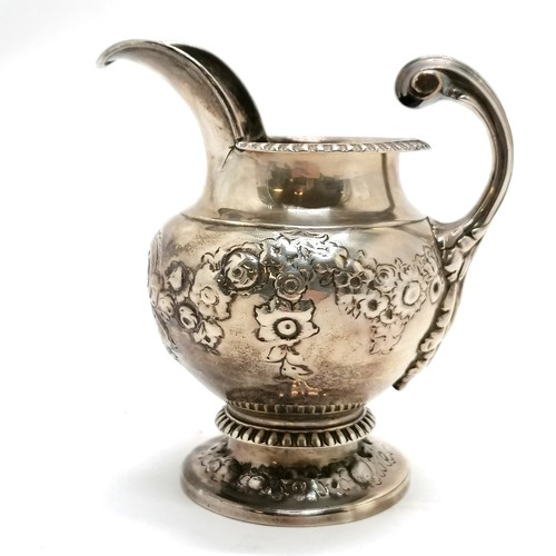 293 - Antique silver embossed cream jug hallmarked London 1812. 240g. 8cm high. fractures to both sides of... 