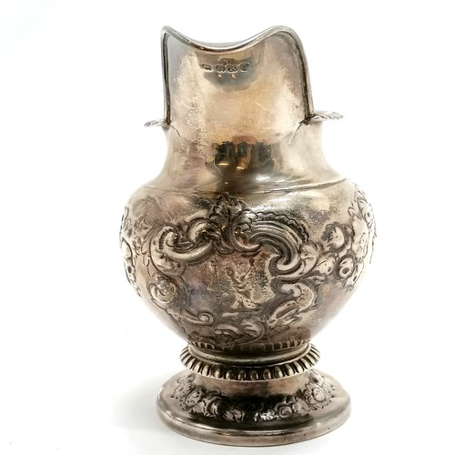 293 - Antique silver embossed cream jug hallmarked London 1812. 240g. 8cm high. fractures to both sides of... 