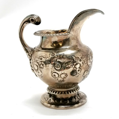 293 - Antique silver embossed cream jug hallmarked London 1812. 240g. 8cm high. fractures to both sides of... 