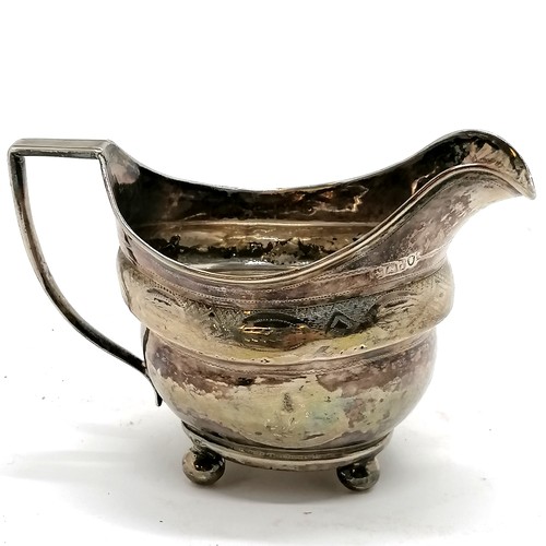 294 - Antique silver cream jug, Exeter hallmarked with chased decoration on 4 bun feet. 9.5cm high. 106g. ... 