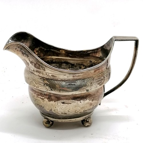 294 - Antique silver cream jug, Exeter hallmarked with chased decoration on 4 bun feet. 9.5cm high. 106g. ... 