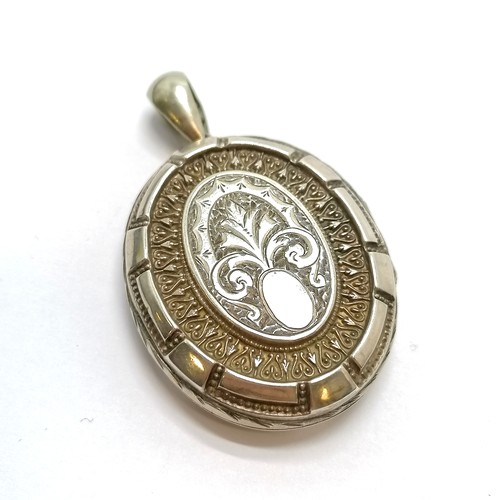 451 - Unmarked antique silver locket pendant with engraved fern decoration - 6cm & 18.8g & in good used co... 