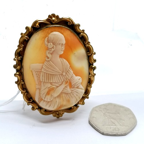 479 - Antique hand carved shell cameo brooch of a seated lady in gilt metal mount - 5.9cm high and has mar... 