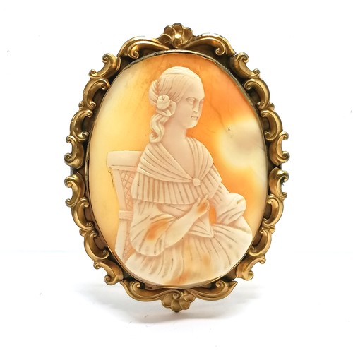 479 - Antique hand carved shell cameo brooch of a seated lady in gilt metal mount - 5.9cm high and has mar... 