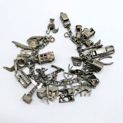 543 - Silver charm bracelet with many charms inc sedan car, Chim opening car charm, sardine tin, flying fi... 