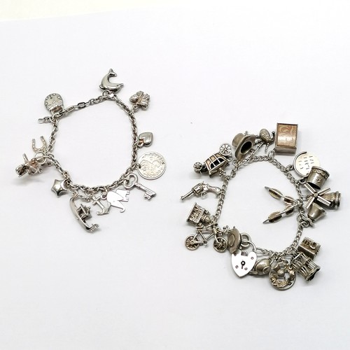 544 - 2 x silver charm bracelets with charms inc 10/- note, 2 x elephants, hats etc - total weight 61g