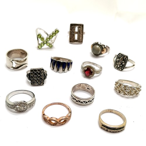 536 - 13 x silver marked rings - peridot set cross, fleur de lis etc - total weight 60g