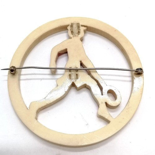 683 - Large early plastics tennis player brooch (7.5cm diameter)