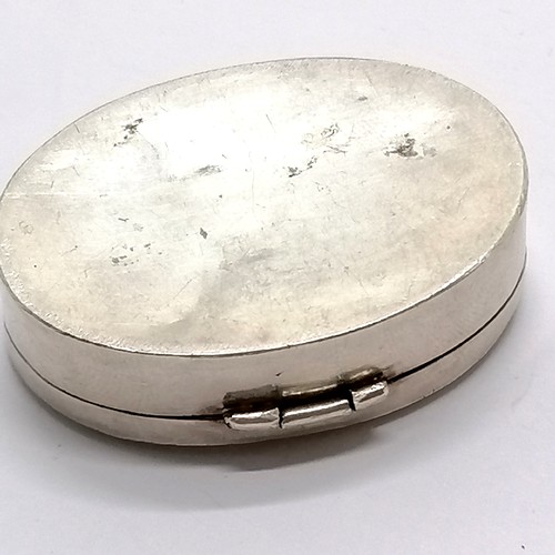 883 - Unmarked silver oval hinged box with enamel detail of a peacock to the lid 4.5cm across 19g- slight ... 