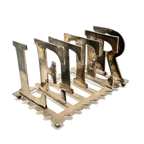 267 - Silver plated letter rack in the form of characters forming the word 