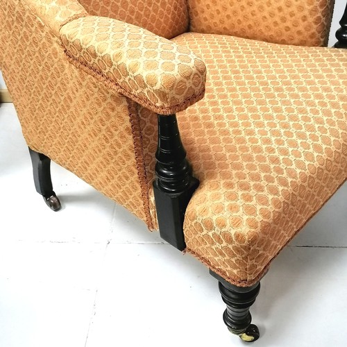 283 - Antique low orange upholstered armchair with castors. 73cm wide x 75cm high x 80cm deep.