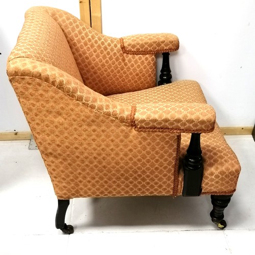 283 - Antique low orange upholstered armchair with castors. 73cm wide x 75cm high x 80cm deep.