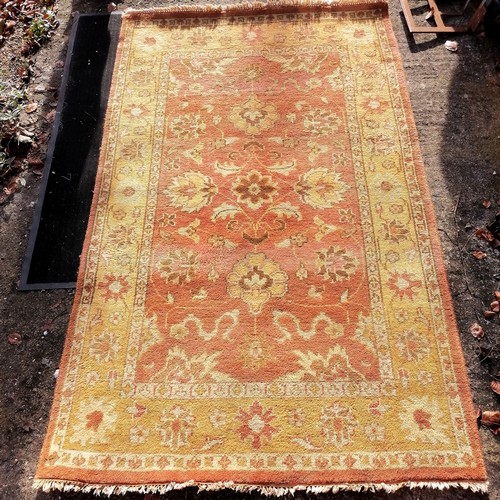 447 - Indian pale yellow and terracotta coloured wool rug - 250cm x 150cm ~ in good used condition