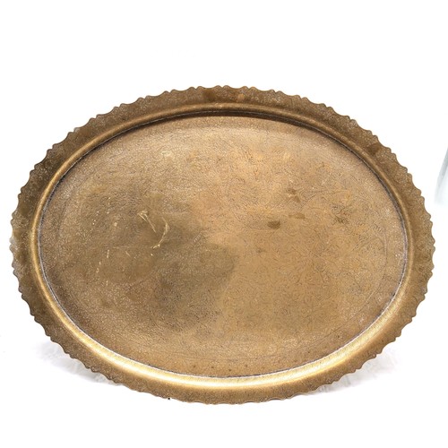 507 - A Brass oval tray, 68 cm x 52 cm t/w embossed tray, Indian brass cigarette box and a bell.