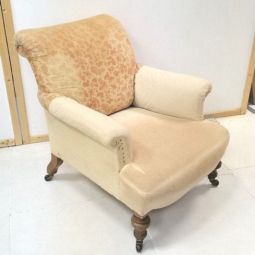 281 - Edwardian oak framed upholstered easy chair on turned legs ending in castors,  82 cm in height, 78 c... 