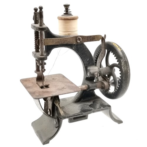 302 - Child's miniature cast iron sewing machine 16.5 cm in height, 15 cm in length, good working order.