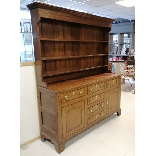 306 - An Antique oak dresser with three tier delft rack, the base having 6 short drawers and 2 cupboards, ... 