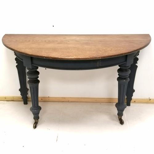 370 - Antique oak blue painted demi lune table with brass castors 31cm wide x 63cm deep x 73cm high & in g... 