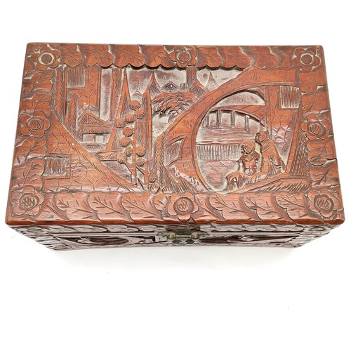 453 - An oriental carved camphorwood box decorated with various carved scenes, complete with lock and key,... 