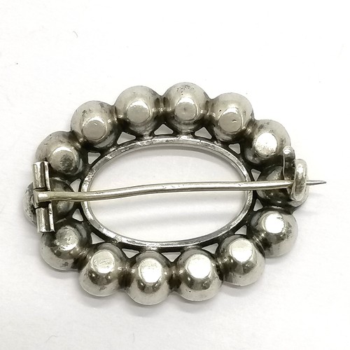718 - Antique unmarked silver and paste brooch with gold detail to inside rim, 4cm across - some wear to s... 