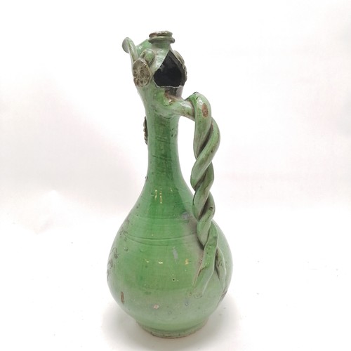 368 - Continental green glazed ewer with twisted handle and paint decoration 36cm high - some losses to th... 