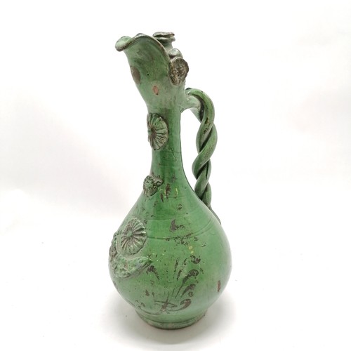 368 - Continental green glazed ewer with twisted handle and paint decoration 36cm high - some losses to th... 