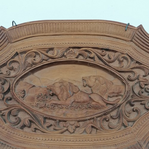 54 - Carved oval plaque depicting lions. 22 x 13cm.