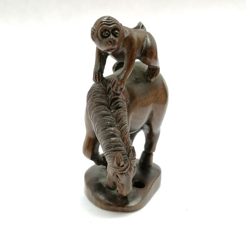 101 - Carved wooden figure of a monkey on a horse as an oriental toggle with bead eyes 5cm high