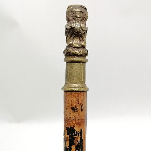 24 - Antique ebonised walking cane with bronze handle depicting a recumbent lion 84cm long- losses to the... 