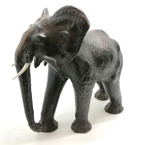 16 - Unusual leather elephant figure - 58cm high x 62cm across ~ signs of wear and both tusks slight a/f