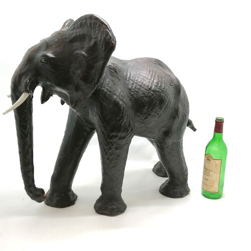 16 - Unusual leather elephant figure - 58cm high x 62cm across ~ signs of wear and both tusks slight a/f