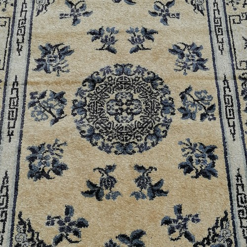 76 - Chinese rug in cream depicting flowers. Measures 153 x 94cm. In very good used condition.