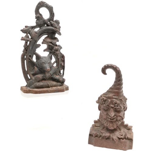 91 - 2 x cast iron doorstops ~ fox hunting related (28cm) & green man (old repair to top of hat)