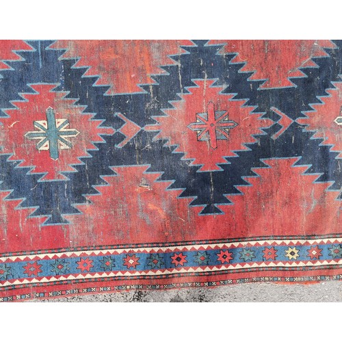 166 - Persian red ground rug with blue geometric central medallions, some repair and ,wear, 145 cm wide, 2... 