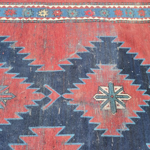 166 - Persian red ground rug with blue geometric central medallions, some repair and ,wear, 145 cm wide, 2... 