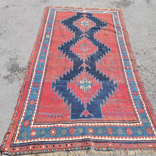 166 - Persian red ground rug with blue geometric central medallions, some repair and ,wear, 145 cm wide, 2... 