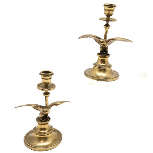 176 - Pair of antique brass candlesticks with eagle detail to centre - 19cm high & in used condition