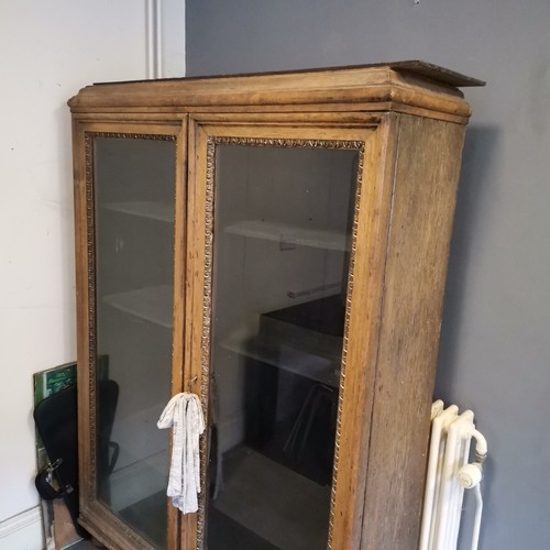 237 - Large oak bevelled glazed 2 door cabinet, on bun feet with original key - base and feet need attenti... 