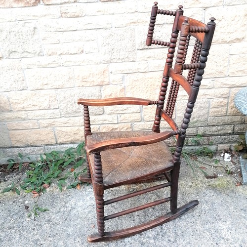 349 - Antique Arts & Crafts (Libertys?) rush seated rocking chair with bobbin turnings - 115cm high x 57cm... 